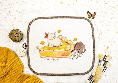 Siuvinėjimo rinkinys su dviem katinukais ant pyrago motyvo, 20×15 cm, parodytas iš viršaus su mediniu lankeliu ir siūlais