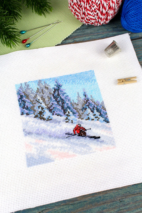 Kryželių rinkinys: žieminė kvadratinė drobė ~20×20 cm su raudonu slidininku, mėlynu dangumi ir siūlais