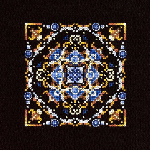 Kryželių rinkinys su mėlynos–auksinės ornamentikos kvadratiniu raštu ant juodo audinio, artimas planas, 25×25 cm
