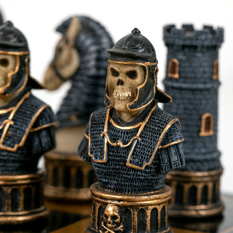 Šachmatų figūra juoda su aukso akcentais, skeletuotas riterio biustas iš priekio, parodo grublėtą tekstūrą ir detales