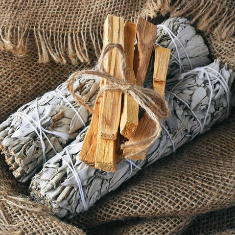Palo santo lazdelės rudos, trijų lazdelų ryšelis ant baltų šalavijo kuokštų ir burlapo, artimas planas