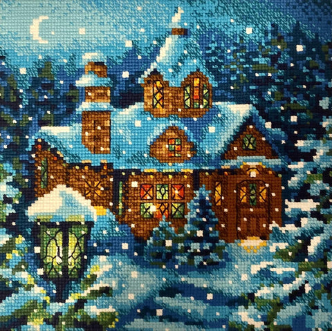 Diamond painting žieminis namelis su mėlyna sniego palete ir šiltai apšviestais langais, baigtas dizainas