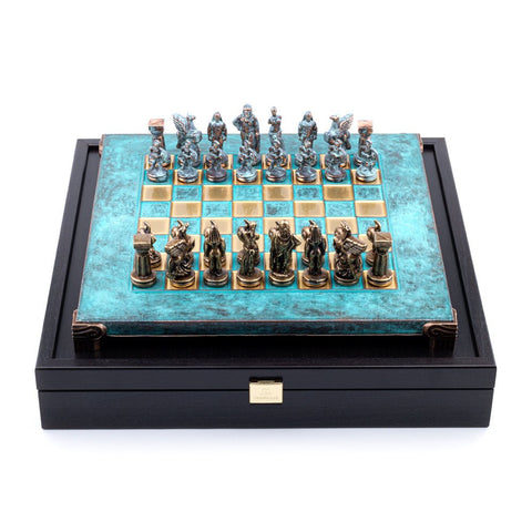Šachmatai ant turkio patinuoto metalinio laukelio su bronzinėmis figūromis ir juoda medine dėže, fotografuoti iš viršaus