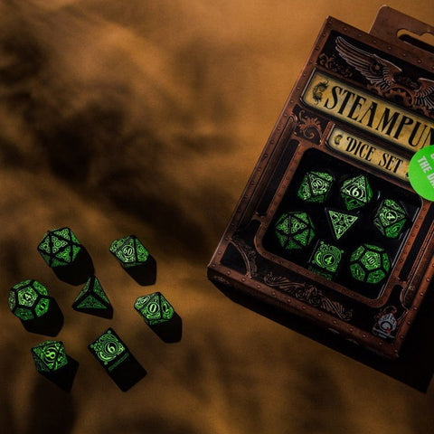 Kauliukų rinkinys Steampunk, fluorescencinės žaliai švytinčios polyedrinės dalys, dėžutėje ir išbarstytas ant fono