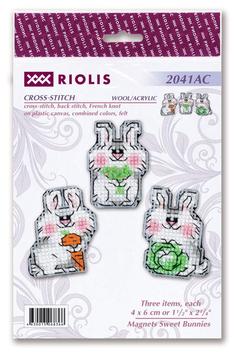 Magnetai Riolis — trijų kryželiu siuvinėtų baltų kiškučių rinkinys (4×6 cm), su morka, gėlėmis ir kopūstu
