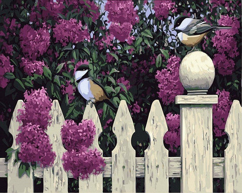 Drobė su violetinėmis alyvomis ir balta medine tvora, dvi zylės ant stulpelio, 60×80 cm vertikalus variantas, puikus sienos akcentas