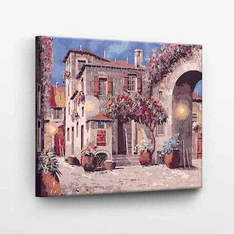Drobė 50×40 cm su Viduržemio miestelio tapyba, įtempta ant medinio rėmo, rodoma iš šono su ryškiomis gėlių vazomis