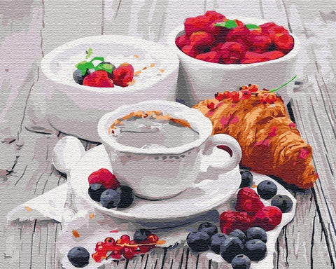 Kava espresso baltame puodelyje ant lėkštutės, pateikta su sviestiniu kruasanu, avietėmis ir mėlynėmis bei jogurtu