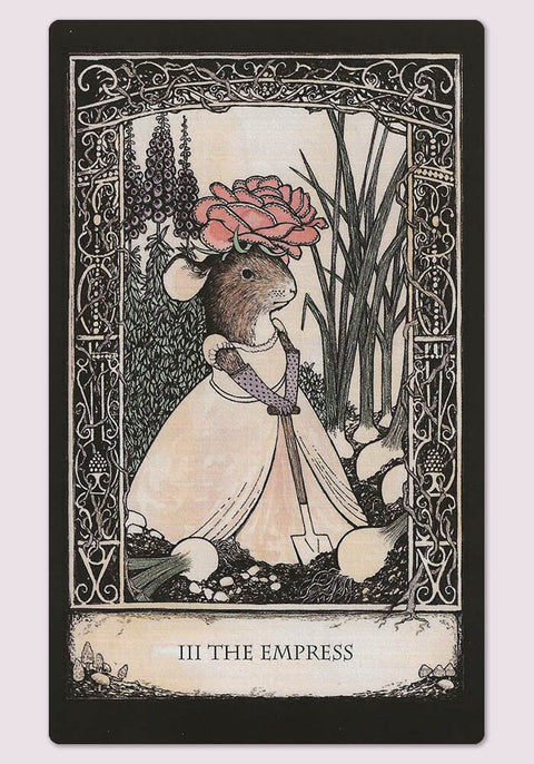 Tarot korta Imperatorė — pelė su rožiniu žiedu ant galvos, balta suknele ir kastuvu sodinimui, ornamentuotas rėmas