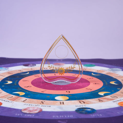 Pendulas iš skaidraus krištolo su auksiniu laurų ornamentu ir spiraliniu pagrindu, centre ant astrologinio rato
