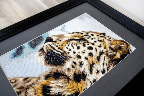 Siuvinėtas leopardo paveikslas, artimas kampu – gelsvai-rudos dygsniuotos faktūros su juoda rėmo apdaila
