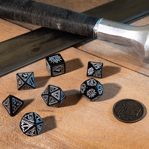 Metaliniai RPG kauliukai juodi su sidabrinėmis graviruotėmis, 8 dalių rinkinys ant medinės lentos šalia monetos ir plaktuko