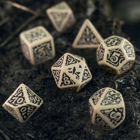 RPG kauliukai ornamentuoti juodai ant kreminio pagrindo, artimas planas su matomu 20‑ ir 10‑šonių kauliukais