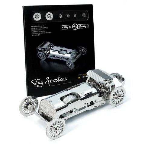 Miniatiūrinis sportinis automobilis sidabrinis, surinktas metalinis modelis iš priekio su juoda pakuote fone