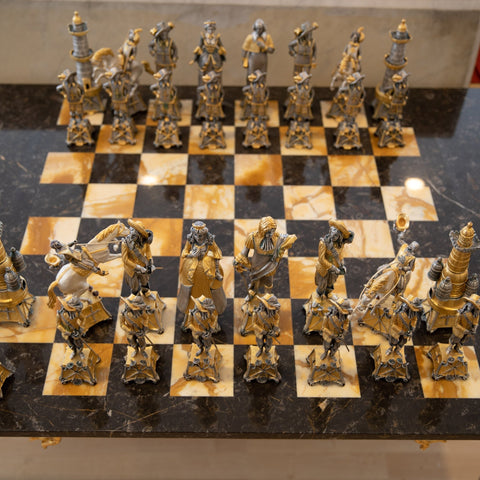 Šachmatų rinkinys iš marmuro lentos su auksinėmis ir sidabrinėmis XVIII a. stiliaus figūrėlėmis, arti priekinės eilės