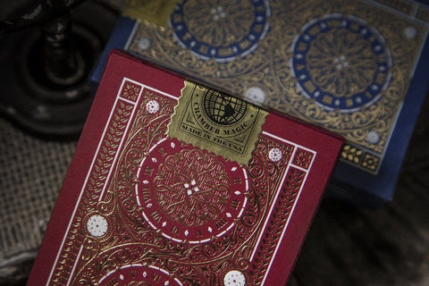 kortų kaladė Chamber Magic raudona su auksiniu antspaudu, artimas kampinis kadras, ryškus ornamentinis nugarėlės dizainas