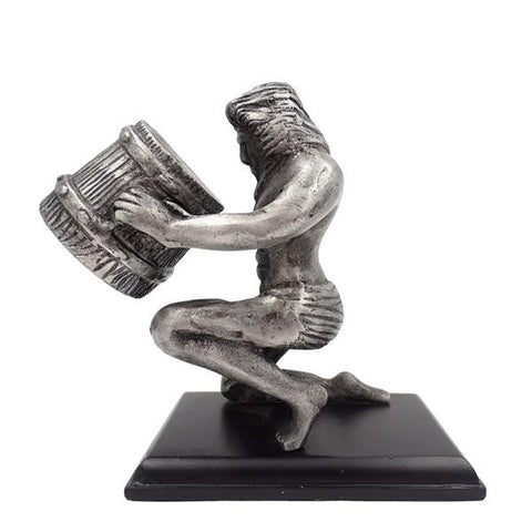 Statuetė sidabrinės spalvos klūpančio vyro, laikančio statinę ant juodo stačiakampio pagrindo, interjero dekoracija