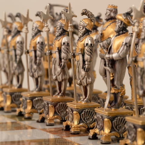 Šachmatų figūros – artimas kampas į sidabro ir aukso kareivius ant dekoratyvios marmurinės lentos, pirmasis planas