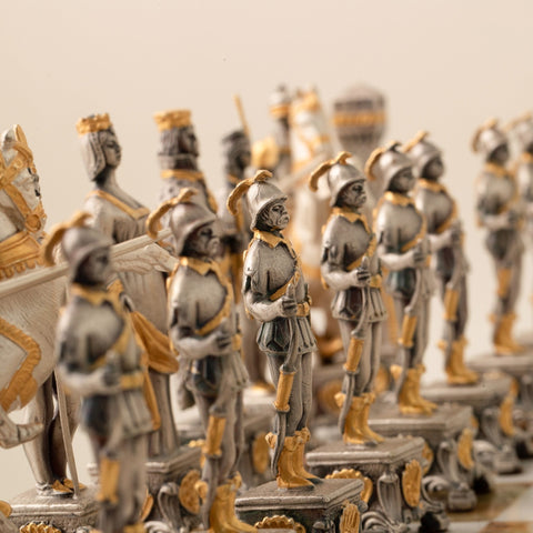 Šachmatų figūros sidabrinės su auksiniais akcentais, kampinis artimas fokusas į stovinčių kareivių eilę