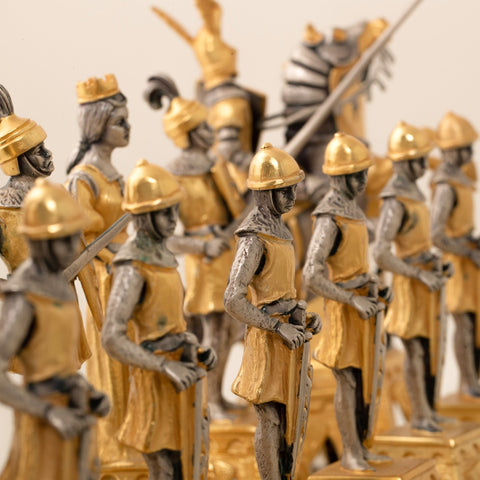 Šachmatai: auksu ir sidabru dengtos viduramžių pėstininkų figūrėlės rikiuotos į priekį, fokusas ant priekinės figūros