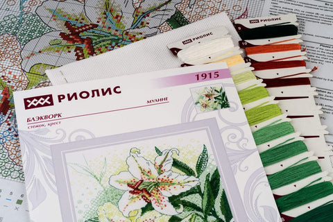 Kryželių siuvinėjimo rinkinys Riolis su baltos lelijos piešiniu ir žaliomis siūlų paletėmis, komplekte schema ir drobė
