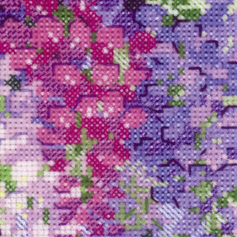 kryželių siuvinėjimas — artimas planas rožinių ir violetinių gėlių rašto, matoma smulkių kryžių ir vilnos siūlų tekstūra