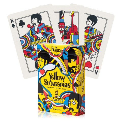 Kortų kaladė The Beatles Yellow Submarine su ryškiai geltona dėžute priekyje ir trimis išleistomis karalių kortomis matomomis fanuotai