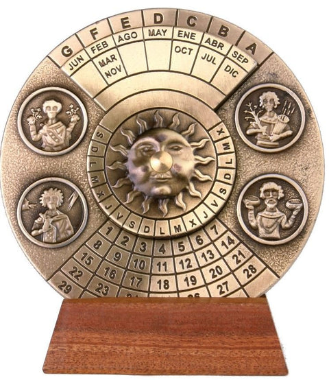 Amžinasis kalendorius bronzinis su saulės motyvu ir sukamais žiedais datoms nustatyti, keturiais medalionais ir mediniu pagrindu