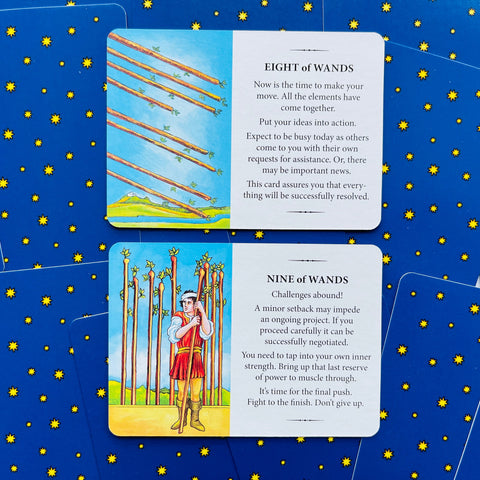 tarot kortos Rider–Waite: dvi kortos (Eight ir Nine of Wands) su iliustracijomis ir paaiškinimais ant mėlyno žvaigždėto fono, matomos iš viršaus