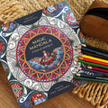 Spalvinimo knyga Magic Mandala su pusiau nuspalvintu mandalos viršeliu, šalia spalvotų pieštukų