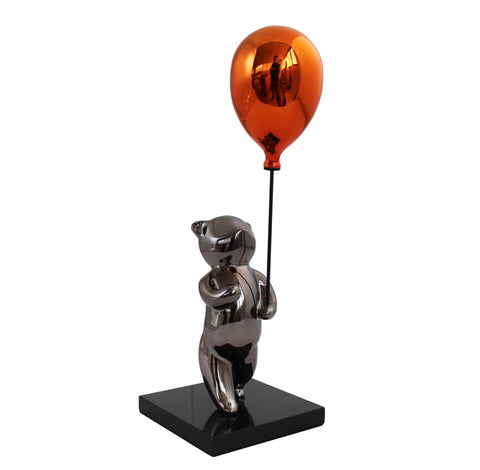Statuetė sidabrinis lokys su oranžiniu metaliniu balionu ant juodo blizgaus pagrindo, pilnas profilis