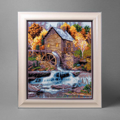 Parduodamas rėminis kryželių paveikslas Vandens malūnas 40×50 cm su ryškiomis rudeninėmis spalvomis, frontalinis vaizdas ir šviesus rėmas