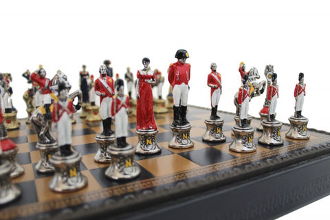 Šachmatai Napoleono tematikos su raudonais ir sidabro figūromis, kampinis artimas planas parodo rankų darbo detales