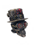 Kaukolė steampunk dekoracija bronzinė su raudonomis akcentų detalėmis, cilindru ir laikrodžio pavaromis, iš šono