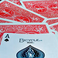 Kortos Bicycle 808 su raudonomis nugarėlėmis, arti fotografuotas pikų tūzas (A) priekyje, pabrėžia aukštą kokybę ir tekstūrą