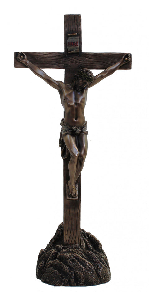 Kryžius su bronzos tonų Kristaus figūra, medžio rašto kryžiumi ir tamsiu akmens pagrindu, skirtas namų altoriui