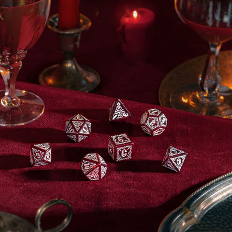 RPG kauliukai raudoni su sidabriniu graviravimu, 7 vnt. metalinis komplektas ant bordo aksominio fono, iš arti