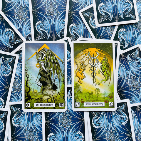 tarot kortos dvi atverstos — The Hermit ir Strength, aiškiai matomi kortų priekiai prieš mėlynus nugarėlių raštus fone