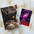 Oracle kortos Guiding Light (Kelly T. Smith) su žvaigždžių dekoruota dėžute ir viena atversta korta Inspired Action