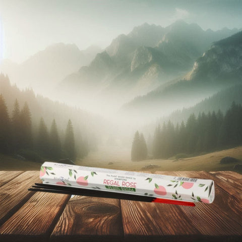 Smilkalai Regal Rose rožių aromato, lazdelės su dekoratyvia pakuote ant medinio stalo, kalnų fone