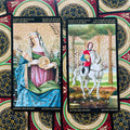 Tarot kortos Monetų rūšis: Karalienė ir Riteris su auksiniais akcentais, žalių ir mėlynų tonų fone
