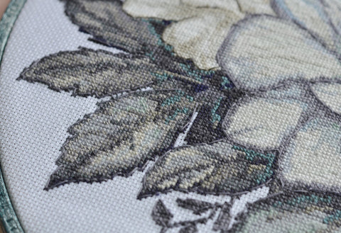 Išsiuvinėtų gėlių žiedlapių siuvinėjimas kryželiu, detalė iš arti
