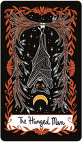 Tarot korta Hanged Man, juoda–oranžinė su kabinančia šikšnate, geltonu pusmėnuliu ir ornamentiniu rėmu