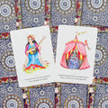 Tarot kortos su akvarelinėmis iliustracijomis — dvi atverstos kortos (meilės ir prognozių motyvai) ant ornamentinių mėlynų nugarėlių, skirtos intuiciniam skaitymui