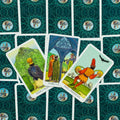 Tarot kortos RWS stiliaus: trys atidengtos monetų kortos (Two, Three, Four of Pentacles) ant žalsvai turkio nugarėlių
