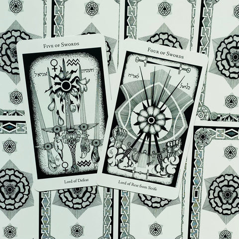 Tarot kortos juodai baltos dizaino, išdėstytos ant raštuoto nugarėlių fono su Five ir Four of Swords kortomis