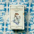 Mini tarot kortos Linestrider — baltas mažų gabaritų dėklas su akvareline moters iliustracija ir autoriaus Siolo Thompson užrašu