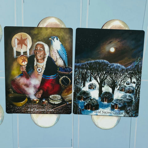 Tarot kortos Sacred Circles, dvi atverstos kortos (9 ir 10) rodo šamanę su sakraliu būgnu ir žiemišką kaimelį