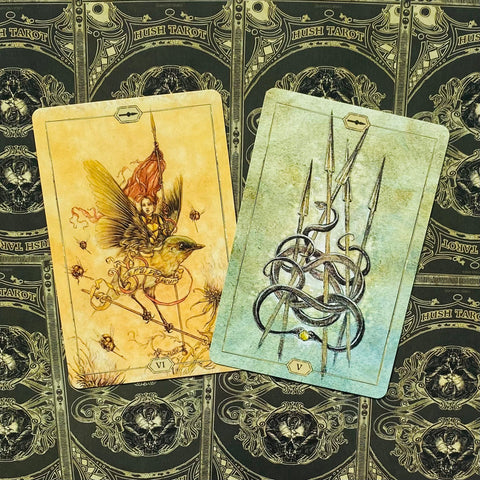 tarot kortos Hush Tarot, dvi variantų kortos — VI su geltonu fėjos dizainu ir V su žaliai-mėlynu ietų motyvu