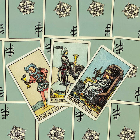 Tarot kortos trijų Taurių rūšių rinkinys: Pažadas (Page), Riteris ir Karalienė kortos išdėstytos ant šviesiai žalių nugarėlių